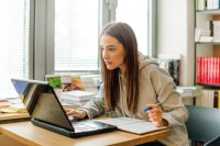 Female student studying laptop screen intently