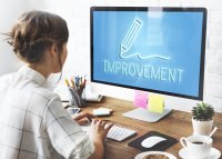 Woman in front of computer with "improvement" written on the screen